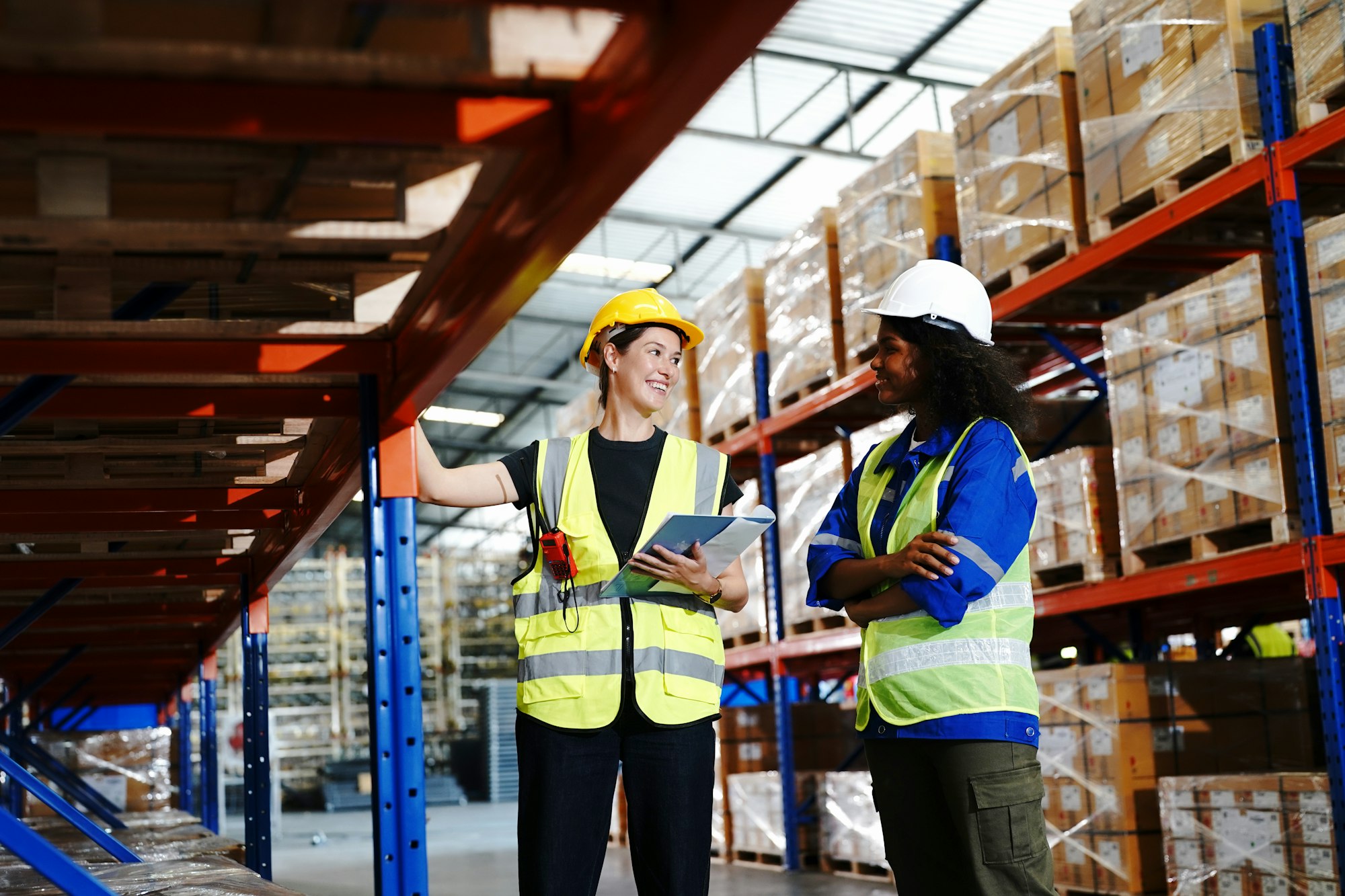 Warehouse workers working in the large logistic distribution warehouse. Workers in reflective cloth