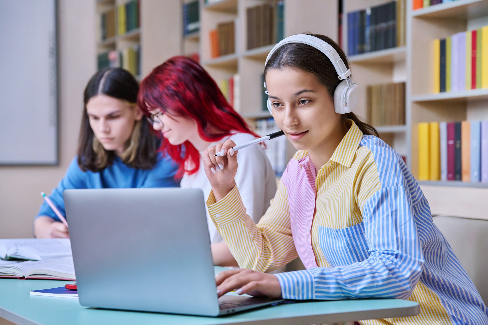 Group of teenage students study in school library